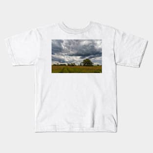 Stormy cloudscape over meadow Kids T-Shirt